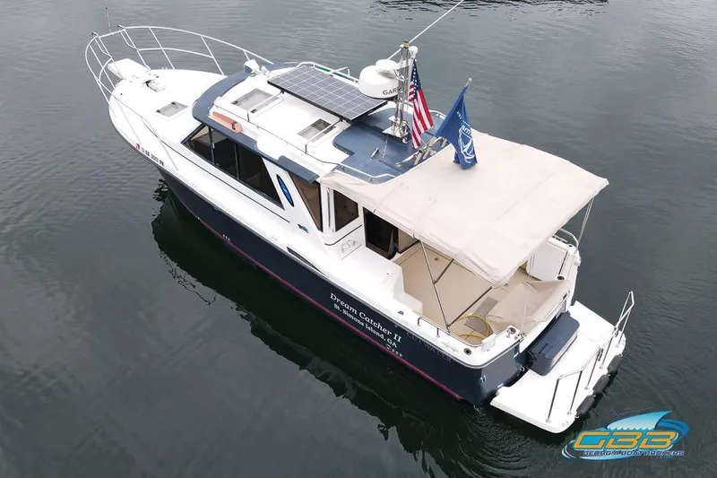  Yacht Photos Pics 2013 Cutwater C-28 boat with solar panels and flags, docked on calm water.