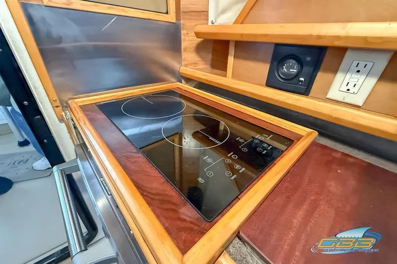  Yacht Photos Pics 2013 Cutwater C-28 boat kitchen with electric stove and wooden cabinetry.