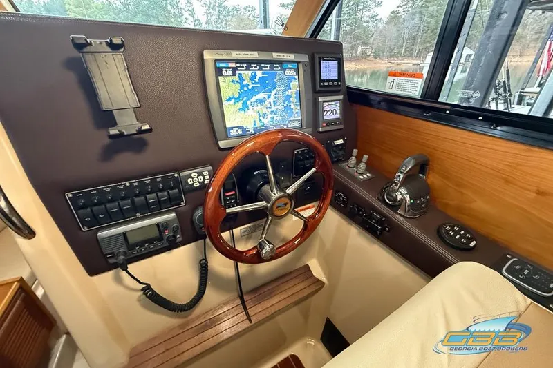  Yacht Photos Pics 2013 Cutwater C-28 helm with navigation display, wooden steering wheel, and control panel.