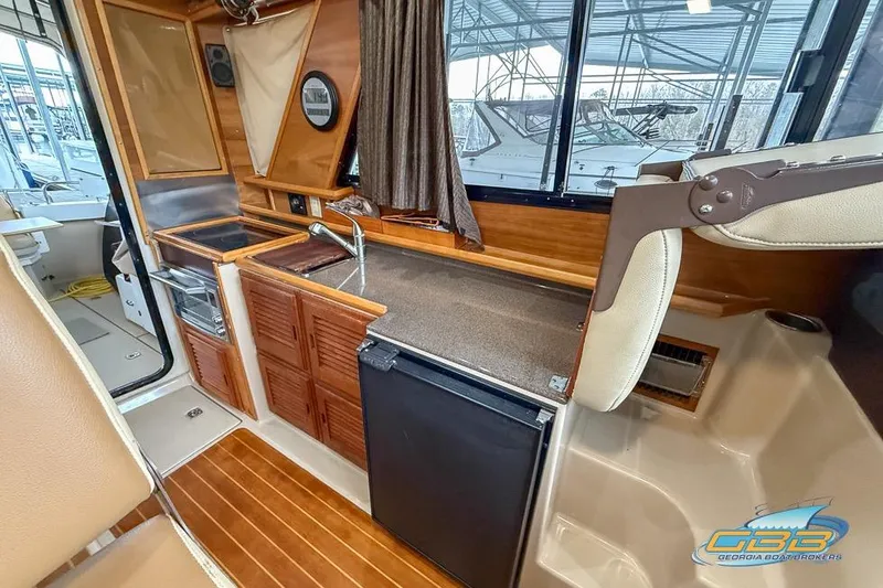  Yacht Photos Pics 2013 Cutwater C-28 boat interior with kitchenette, wood cabinetry, and compact appliances.