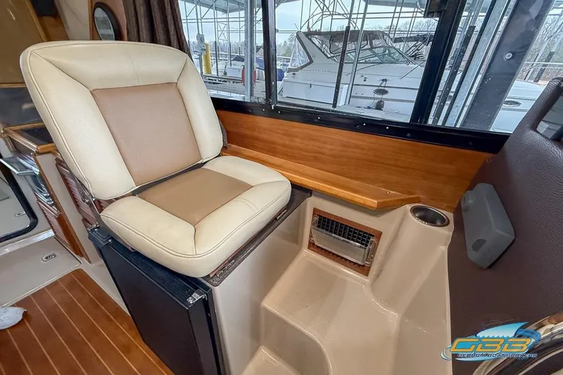  Yacht Photos Pics Interior of a 2013 Cutwater C-28 boat featuring a cushioned seat and wooden accents.