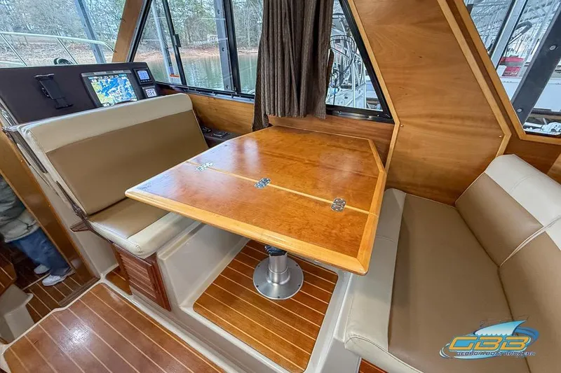  Yacht Photos Pics 2013 Cutwater C-28 interior with wooden table, cushioned seating, and navigation equipment.