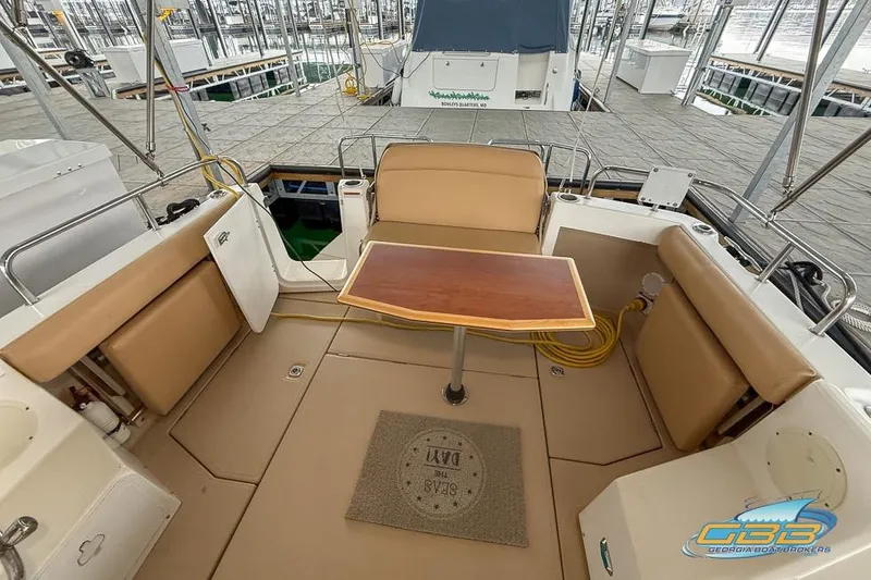  Yacht Photos Pics 2013 Cutwater C-28 boat interior with tan seating and wooden table in a marina setting.