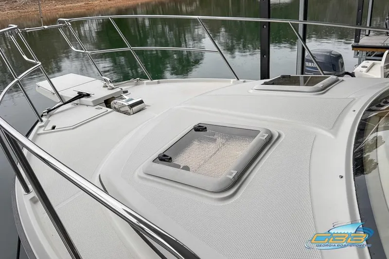  Yacht Photos Pics 2013 Cutwater C-28 boat deck with hatches and railing, docked by calm water.