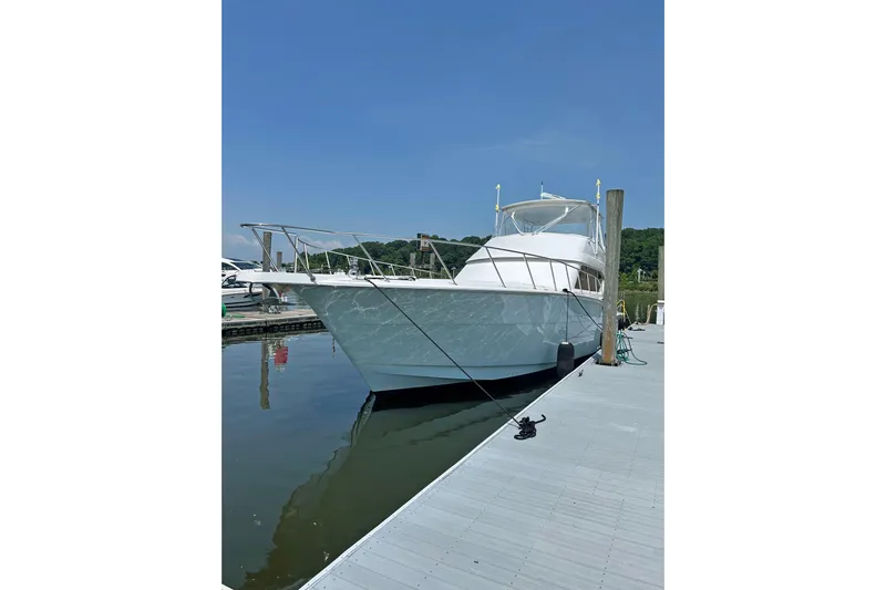 Empress Yacht Photos Pics 2000 Hatteras 60 Convertible yacht docked at marina under clear blue sky.