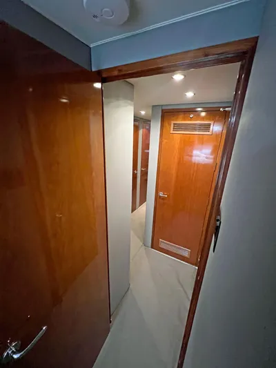 Empress Yacht Photos Pics Interior hallway of 2000 Hatteras 60 Convertible yacht with wooden doors and modern lighting.