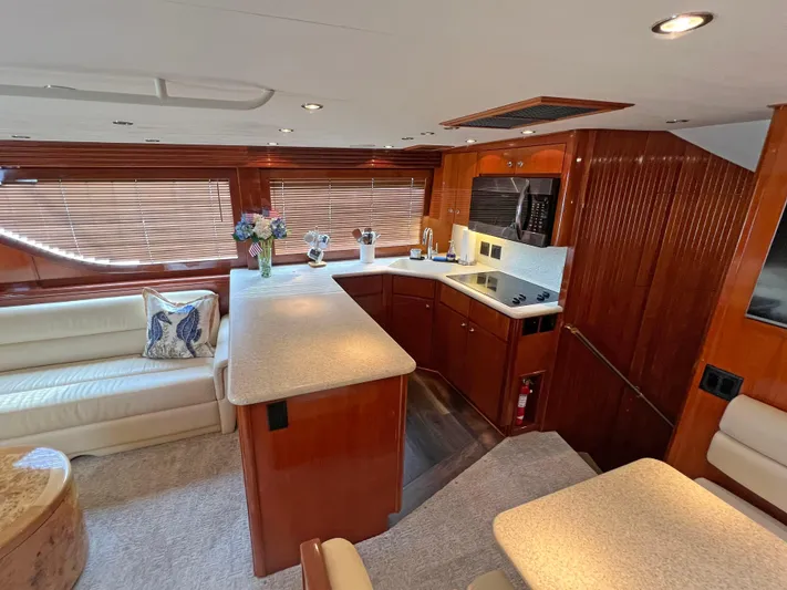 Empress Yacht Photos Pics Luxurious interior of 2000 Hatteras 60 Convertible yacht with modern kitchen and seating area.