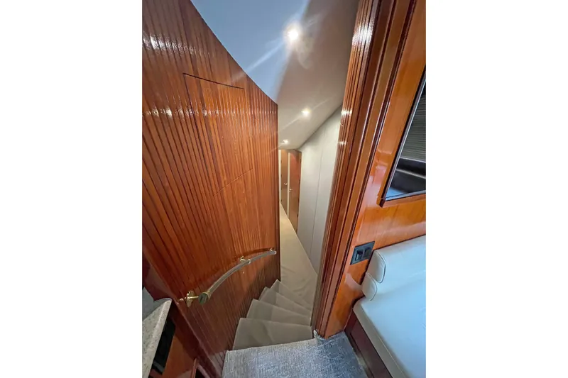 Empress Yacht Photos Pics Interior staircase of 2000 Hatteras 60 Convertible yacht with polished wood finish.