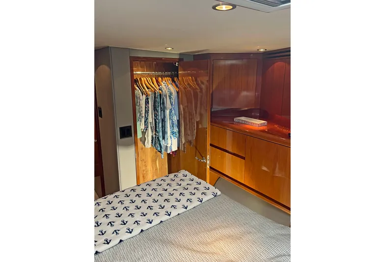 Empress Yacht Photos Pics Luxurious cabin interior of 2000 Hatteras 60 Convertible yacht with wooden closet and bed.