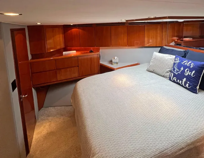Empress Yacht Photos Pics Luxurious bedroom interior of 2000 Hatteras 60 Convertible yacht with wooden cabinetry.
