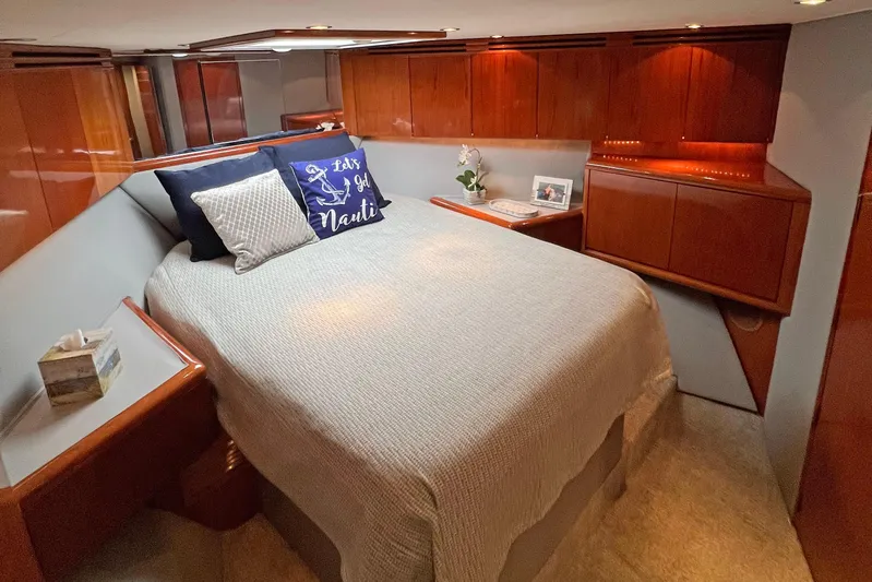 Empress Yacht Photos Pics Luxurious bedroom interior of 2000 Hatteras 60 Convertible yacht with elegant wood finishes.
