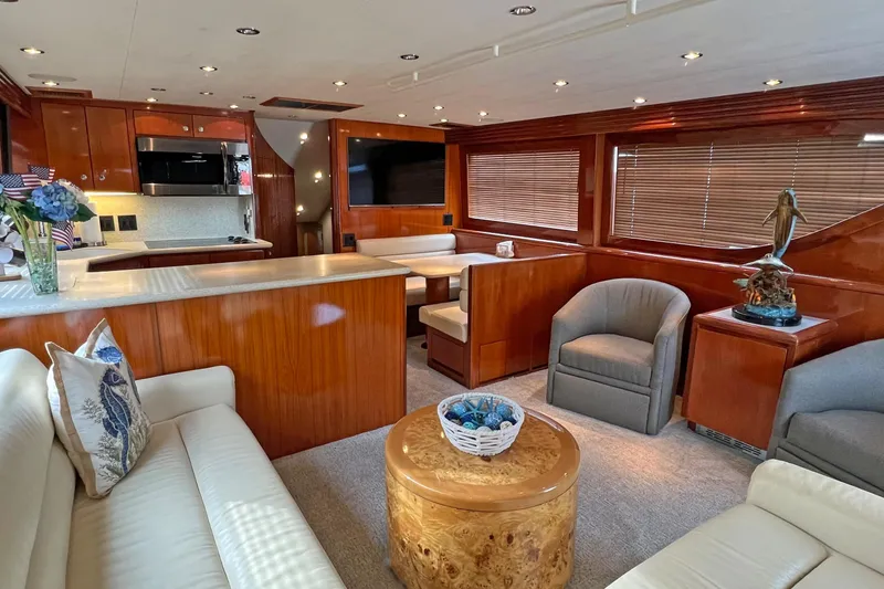 Empress Yacht Photos Pics Luxurious interior of 2000 Hatteras 60 Convertible yacht with elegant wood finishes and cozy seating.