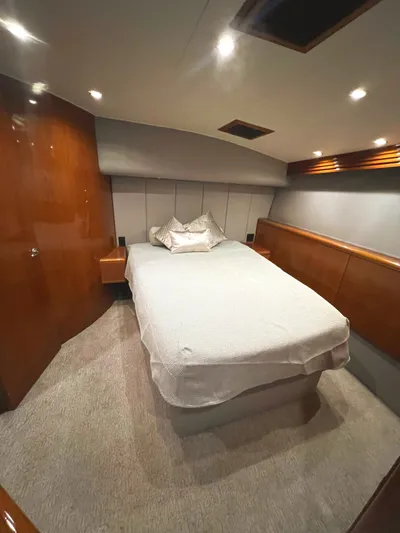 Empress Yacht Photos Pics Luxurious bedroom interior of 2000 Hatteras 60 Convertible yacht with cozy bed and wood paneling.