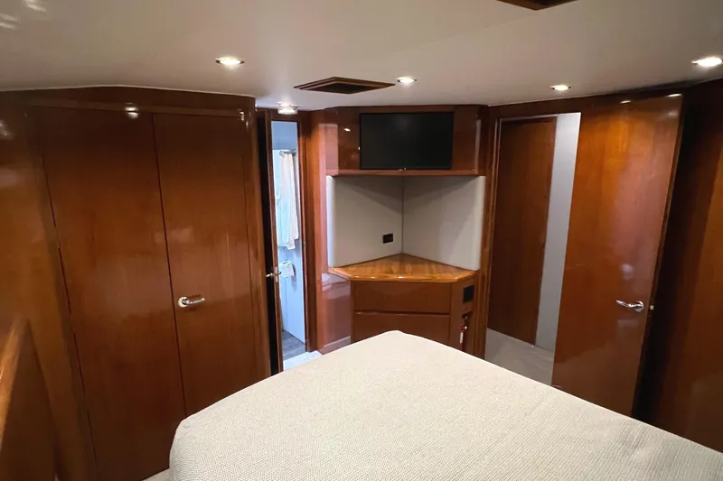 Empress Yacht Photos Pics Luxurious cabin interior of 2000 Hatteras 60 Convertible yacht with wood paneling and modern amenities.