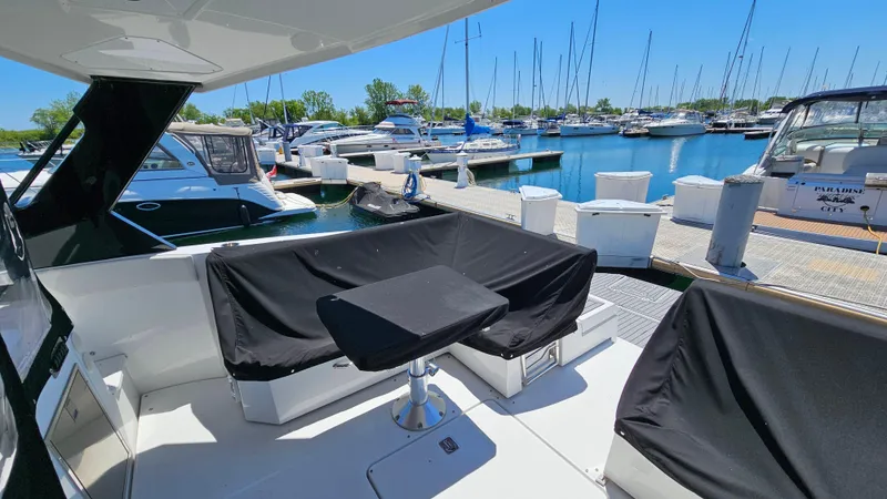  Yacht Photos Pics 2017 Cruisers Yachts 390 Express Coupe at marina, featuring covered seating and table.