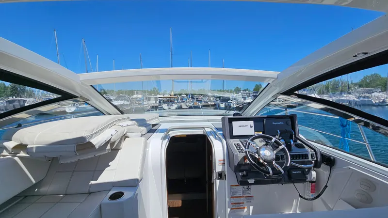  Yacht Photos Pics 2017 Cruisers Yachts 390 Express Coupe interior with helm and seating, docked in marina.