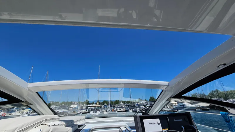  Yacht Photos Pics 2017 Cruisers Yachts 390 Express Coupe interior with marina view under clear blue sky.