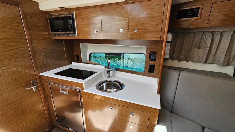  Yacht Photos Pics 2017 Cruisers Yachts 390 Express Coupe interior kitchen with modern amenities and wood cabinetry.