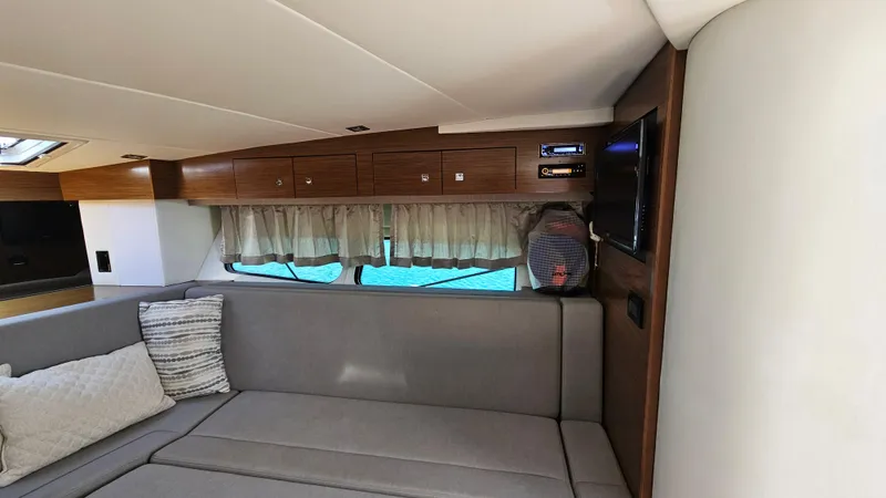  Yacht Photos Pics Interior of 2017 Cruisers Yachts 390 Express Coupe with sofa, TV, and wooden cabinets.