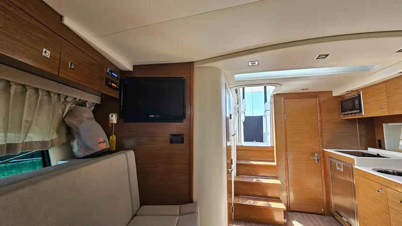  Yacht Photos Pics Interior of 2017 Cruisers Yachts 390 Express Coupe, featuring modern wood finishes and cozy seating.
