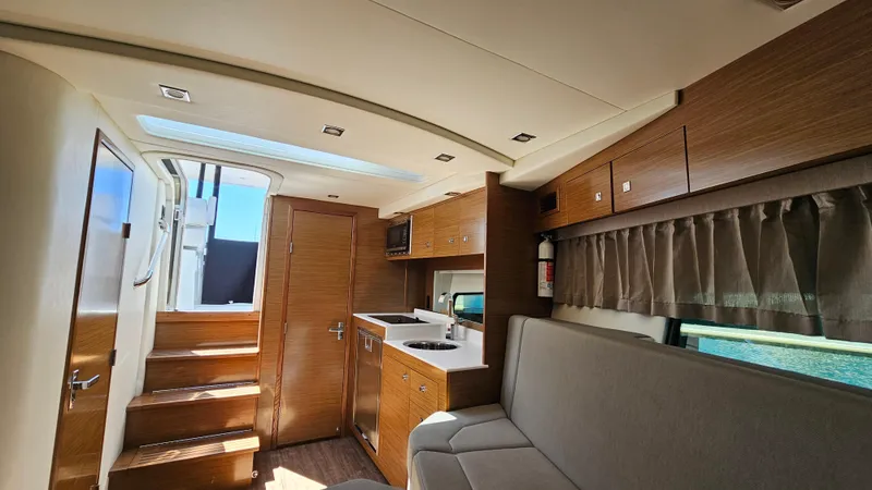  Yacht Photos Pics 2017 Cruisers Yachts 390 Express Coupe interior with modern kitchen and seating area.