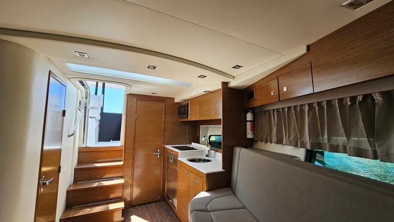  Yacht Photos Pics Interior of 2017 Cruisers Yachts 390 Express Coupe with modern wood finish and compact kitchen.