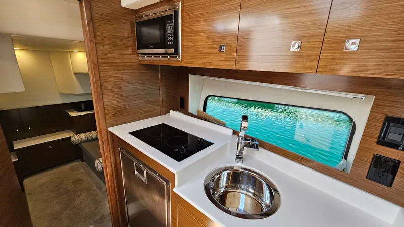  Yacht Photos Pics 2017 Cruisers Yachts 390 Express Coupe interior with modern kitchen and sleek wood cabinetry.