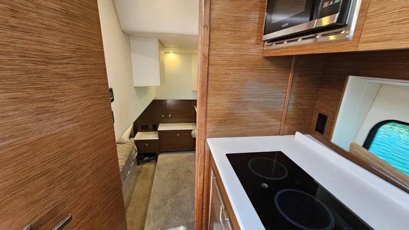  Yacht Photos Pics 2017 Cruisers Yachts 390 Express Coupe interior with modern kitchen and cozy sleeping area.