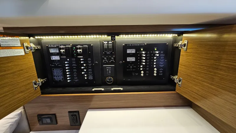  Yacht Photos Pics 2017 Cruisers Yachts 390 Express Coupe electrical panel with LED lighting and wooden cabinetry.