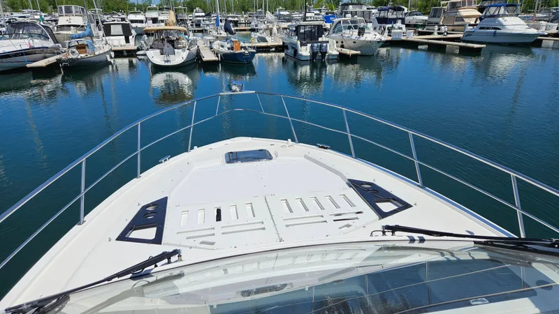  Yacht Photos Pics 2017 Cruisers Yachts 390 Express Coupe docked in a marina with other boats.