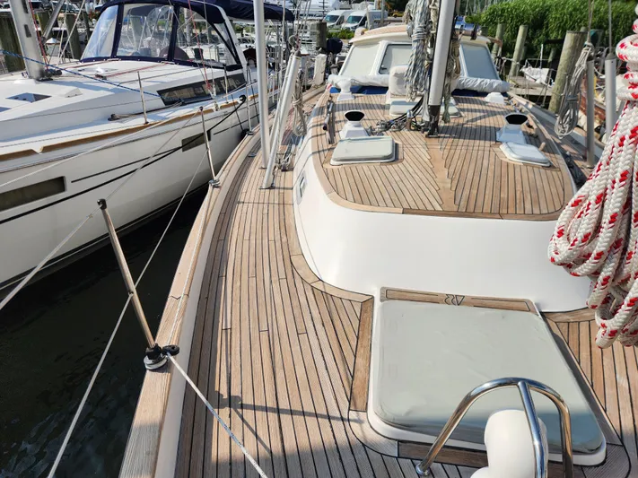 Bella Rose Yacht Photos Pics 2006 Hallberg-Rassy 48 sailboat with teak deck, docked alongside another vessel.