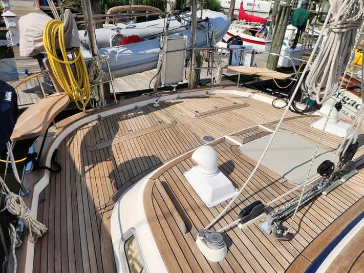 Bella Rose Yacht Photos Pics Teak deck of 2006 Hallberg-Rassy 48 sailboat, featuring rigging and equipment at a marina.