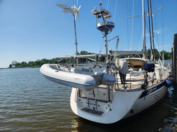 Bella Rose Yacht Photos Pics Sailing yacht Hallberg-Rassy 48 (2006) docked with inflatable dinghy, clear sky, and calm waters.