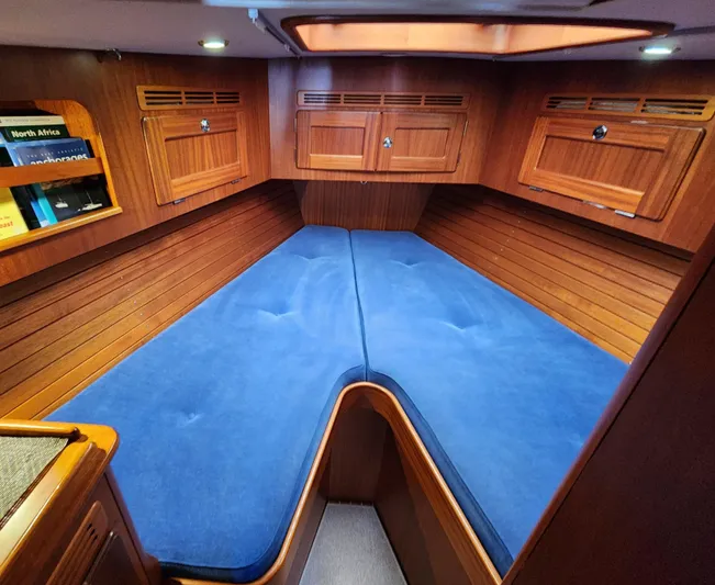 Bella Rose Yacht Photos Pics Interior cabin of 2006 Hallberg-Rassy 48 yacht with blue cushions and wooden finish.