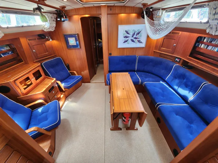 Bella Rose Yacht Photos Pics Luxurious 2006 Hallberg-Rassy 48 yacht interior with blue seating and wooden finishes.