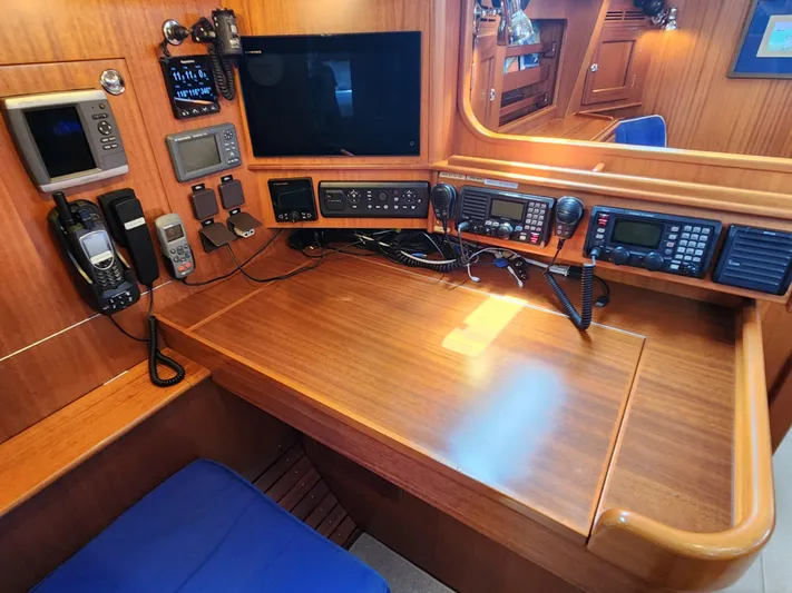 Bella Rose Yacht Photos Pics Navigation station of a 2006 Hallberg-Rassy 48 yacht with communication equipment.