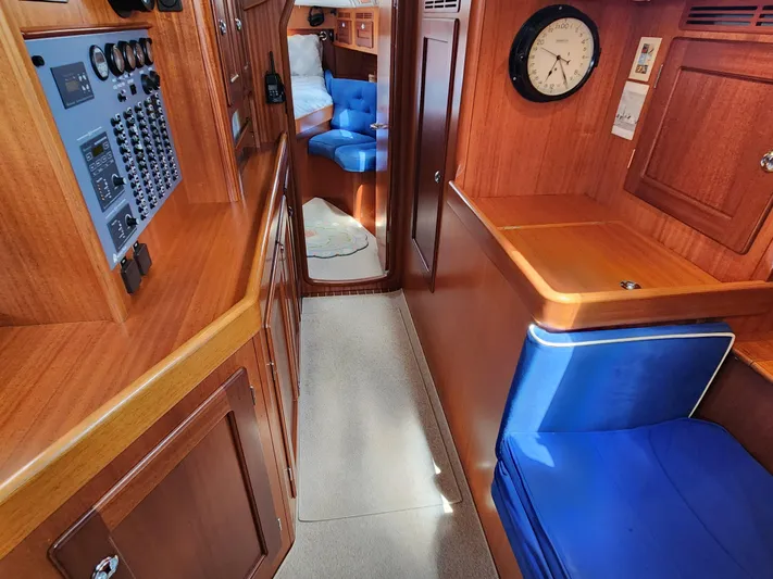 Bella Rose Yacht Photos Pics Interior of 2006 Hallberg-Rassy 48 yacht with wood paneling and blue seating.