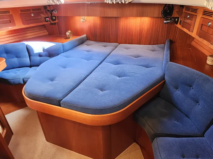 Bella Rose Yacht Photos Pics Luxurious 2006 Hallberg-Rassy 48 yacht interior with blue upholstery and wooden accents.