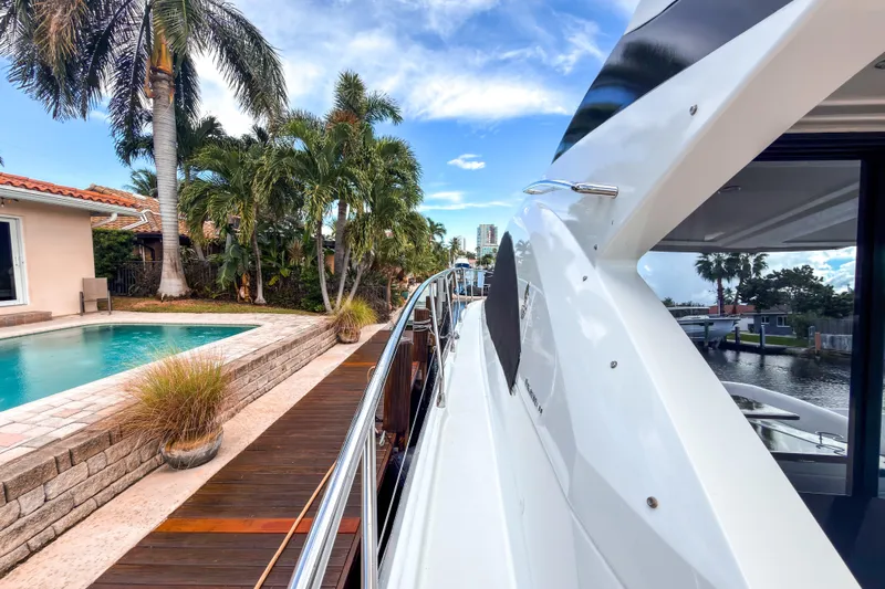  Yacht Photos Pics 2015 Beneteau Gran Turismo 49 yacht docked near a poolside with palm trees.