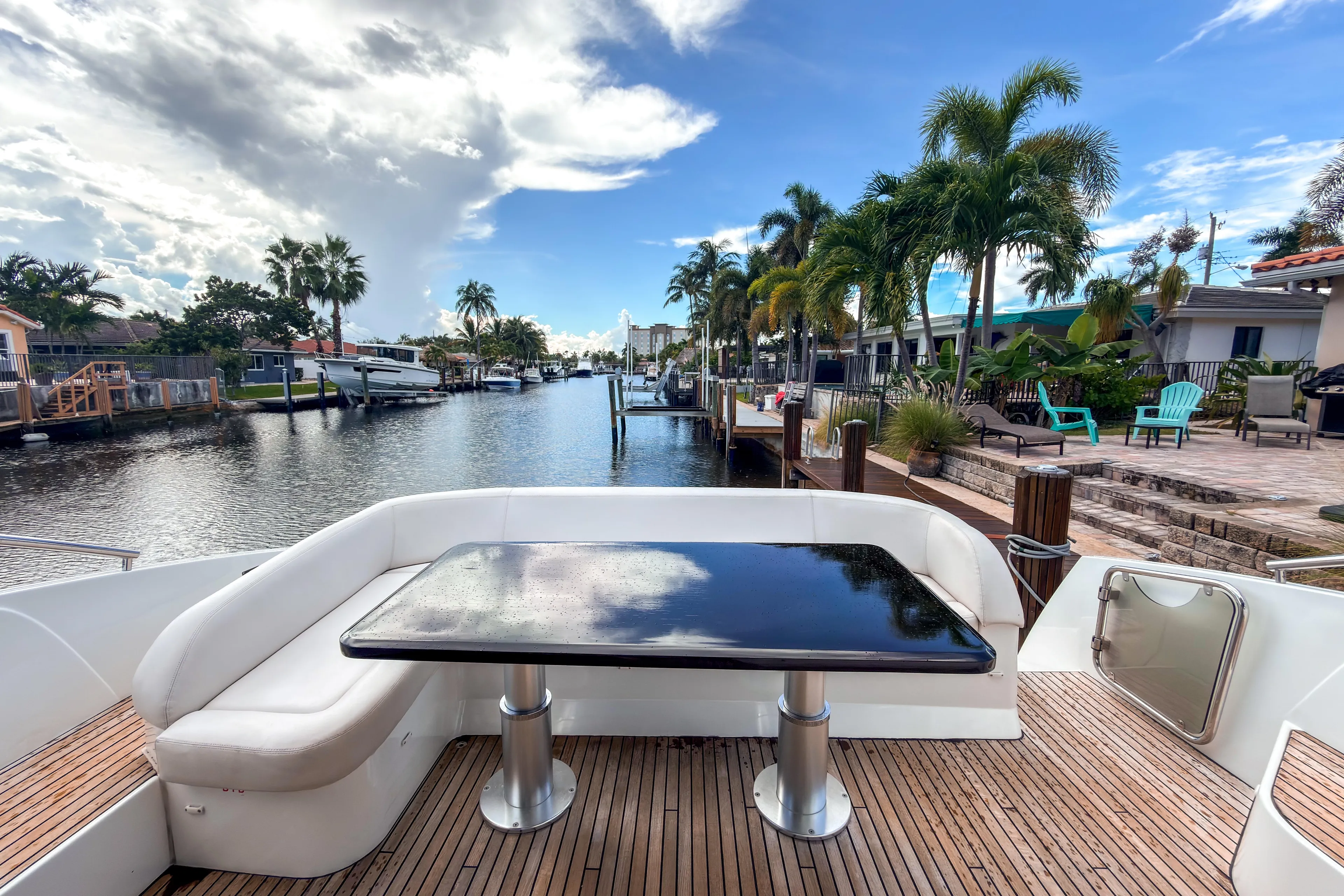  Yacht Photos Pics Beneteau Gran Turismo 49 yacht deck with waterfront view, palm trees, and clear sky.