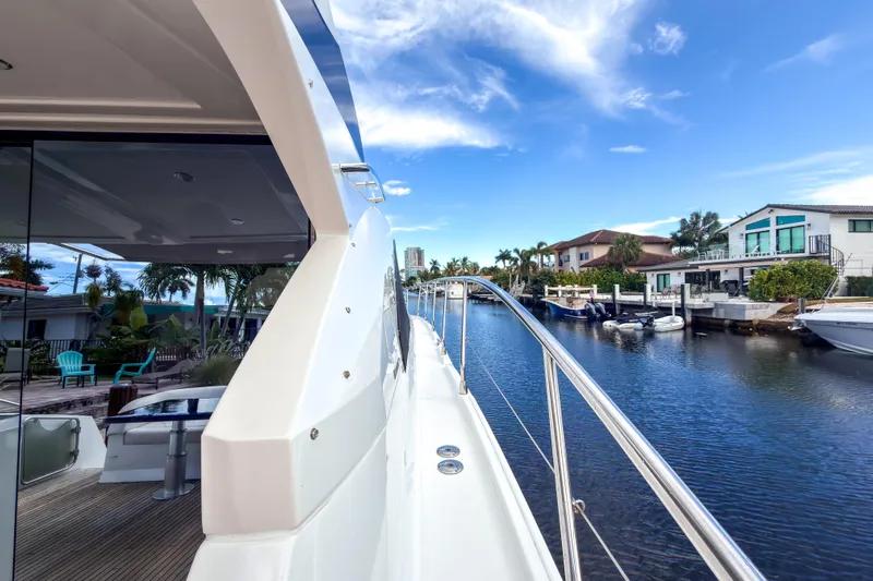  Yacht Photos Pics 2015 Beneteau Gran Turismo 49 yacht docked by waterfront homes under blue sky.