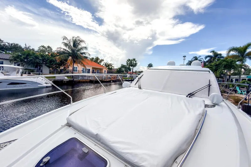  Yacht Photos Pics 2015 Beneteau Gran Turismo 49 yacht docked by palm trees and waterfront homes.