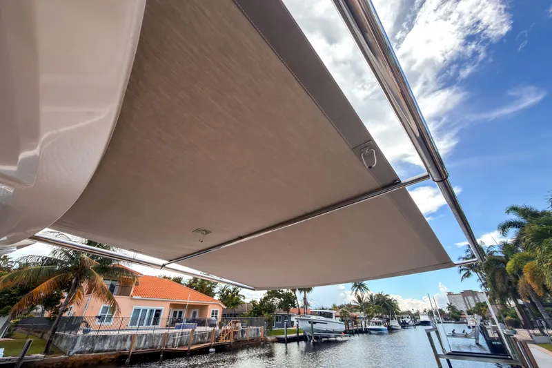  Yacht Photos Pics 2015 Beneteau Gran Turismo 49 yacht with extended sunshade, docked by a canal.