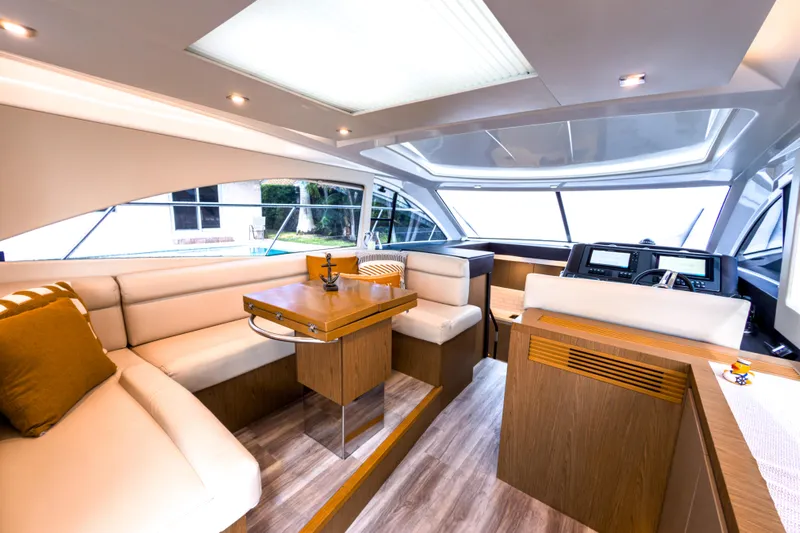  Yacht Photos Pics Luxurious interior of 2015 Beneteau Gran Turismo 49 yacht with modern seating and navigation area.