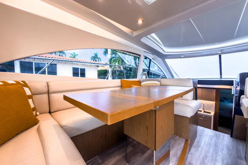  Yacht Photos Pics Luxurious interior of 2015 Beneteau Gran Turismo 49 yacht with elegant seating and wooden table.