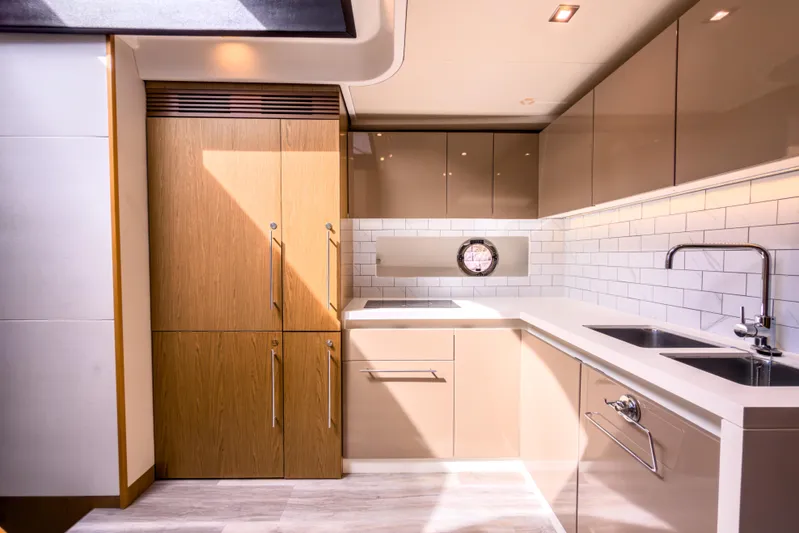  Yacht Photos Pics Luxurious kitchen interior of 2015 Beneteau Gran Turismo 49 yacht, featuring modern cabinetry and fixtures.