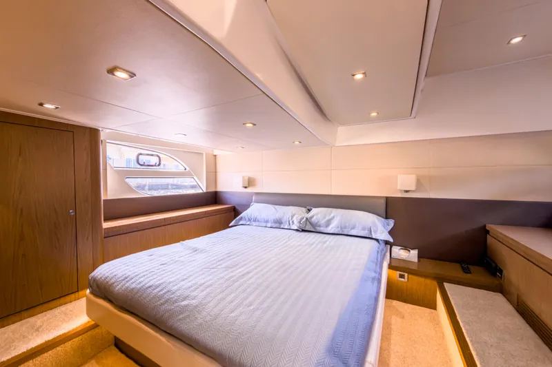  Yacht Photos Pics Luxurious bedroom interior of 2015 Beneteau Gran Turismo 49 yacht, featuring elegant design and cozy ambiance.