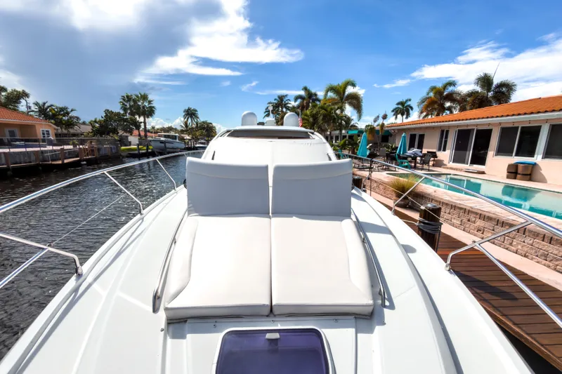  Yacht Photos Pics 2015 Beneteau Gran Turismo 49 yacht docked by waterfront homes, sunny day.