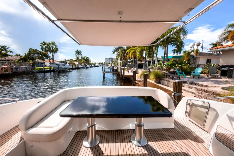  Yacht Photos Pics 2015 Beneteau Gran Turismo 49 yacht deck with seating, table, and waterfront view.
