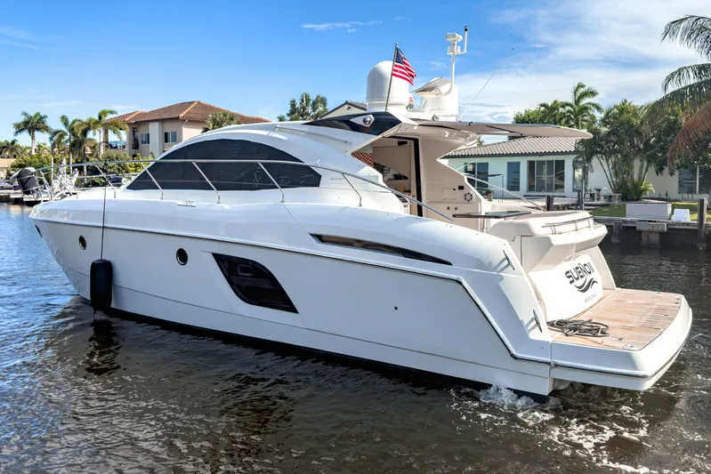  Yacht Photos Pics 2015 Beneteau Gran Turismo 49 yacht cruising on a sunny day near waterfront homes.